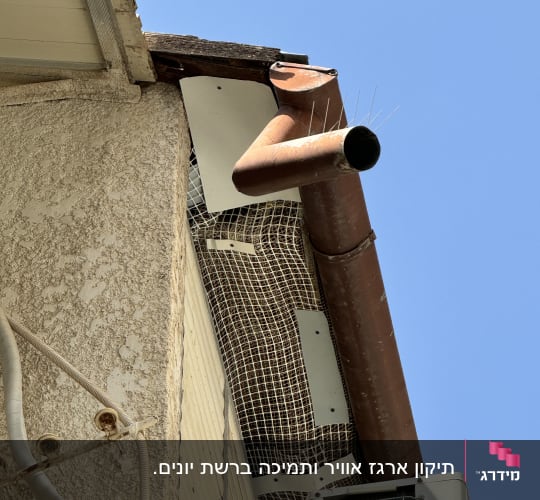 צינור מתכת על גג עם רשת מגן